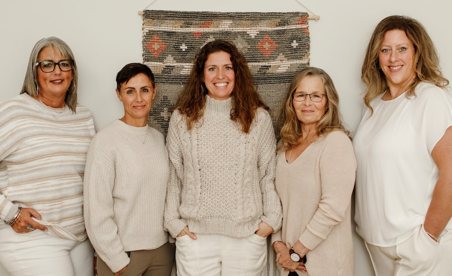 5 women standing by wall