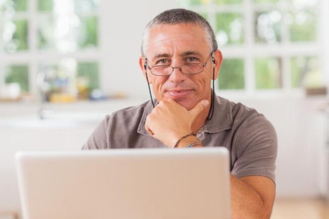 mature man smiling with laptop