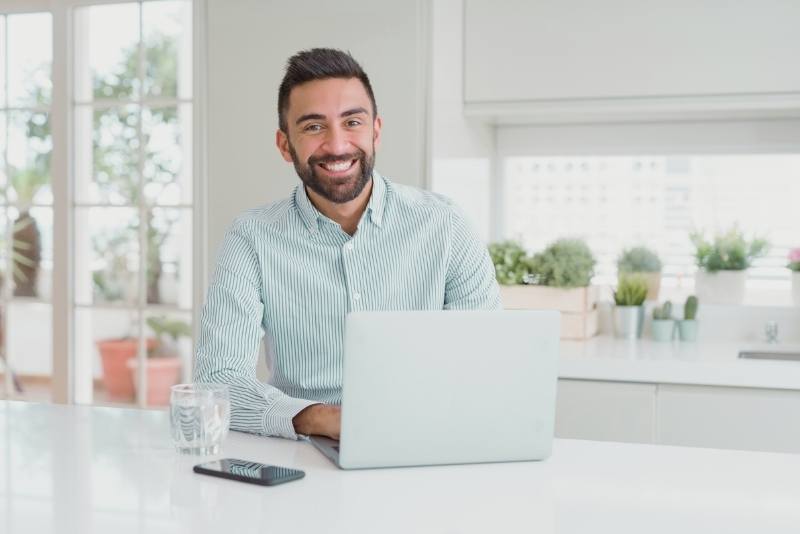 man smiling with laptop